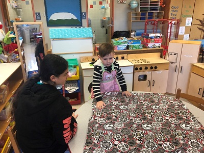 Olympic Heights Early Childhood Education Academy student Arianna Wigodner (left) looks on as Little Lions student Alexander Taylor prepares to learn how to bake.