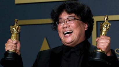 Parasite director and co-producer Bong Joon-ho shows off his Best Picture and Best Director Awards Awards.