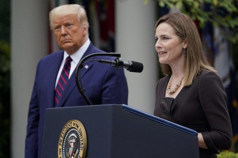 Supreme Court justice nominee Amy Coney Barrett addresses the gathering at her nomination announcement as President Donald Trump looks on.