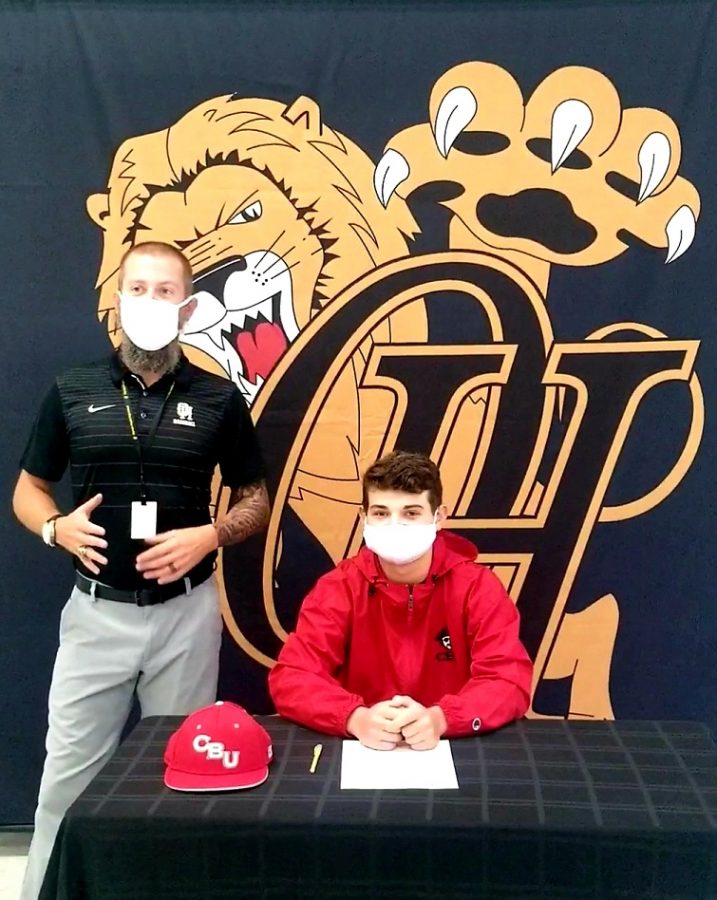 Jake+Neese%2C+seated%2C+with+OH+head+baseball+coach+Casey+Beck%2C+signs+his+letter+of+intent+to+play+baseball+at+Christian+Brothers+University+in+Memphis%2C+Tenn.