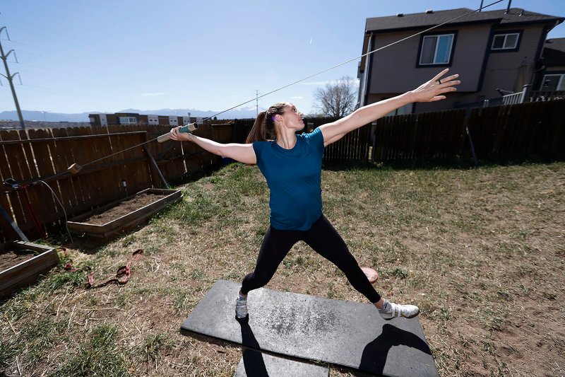 Kara Winger, a three-time Olympian and the U.S. national record holder in the javelin, uses a cable system to simulate throwing a javelin as she trains outside her home in Colorado Springs.