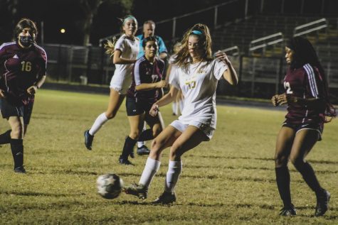 Olympic Heights junior forward Lindsey Osinoff (#45 in white) passes the ball in a game against Lake Worth. Osinoff leads the district in goals scored and points total.